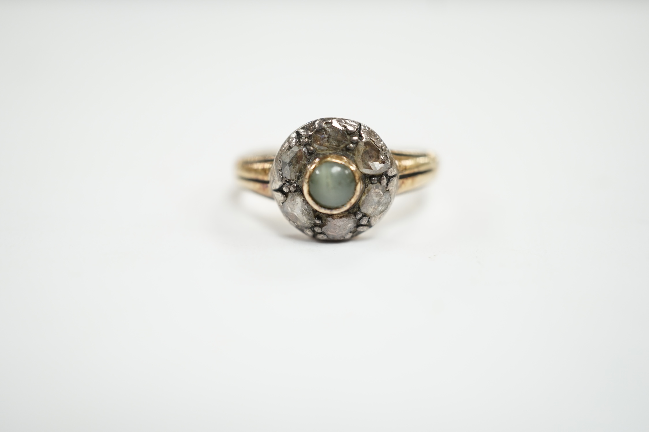 An early 20th century 18ct, cat's eye chrysoberyl and rose cut diamond set circular cluster ring, size M, gross weight 4.6 grams.